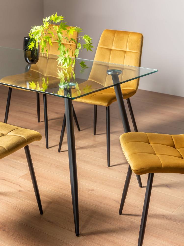 Close Up of the Bentley Designs Martini Clear Tempered Glass 6 Seater Dining Table & 4 Mondrian Mustard Velvet Fabric Chairs with Sand Black Powder Coated Legs