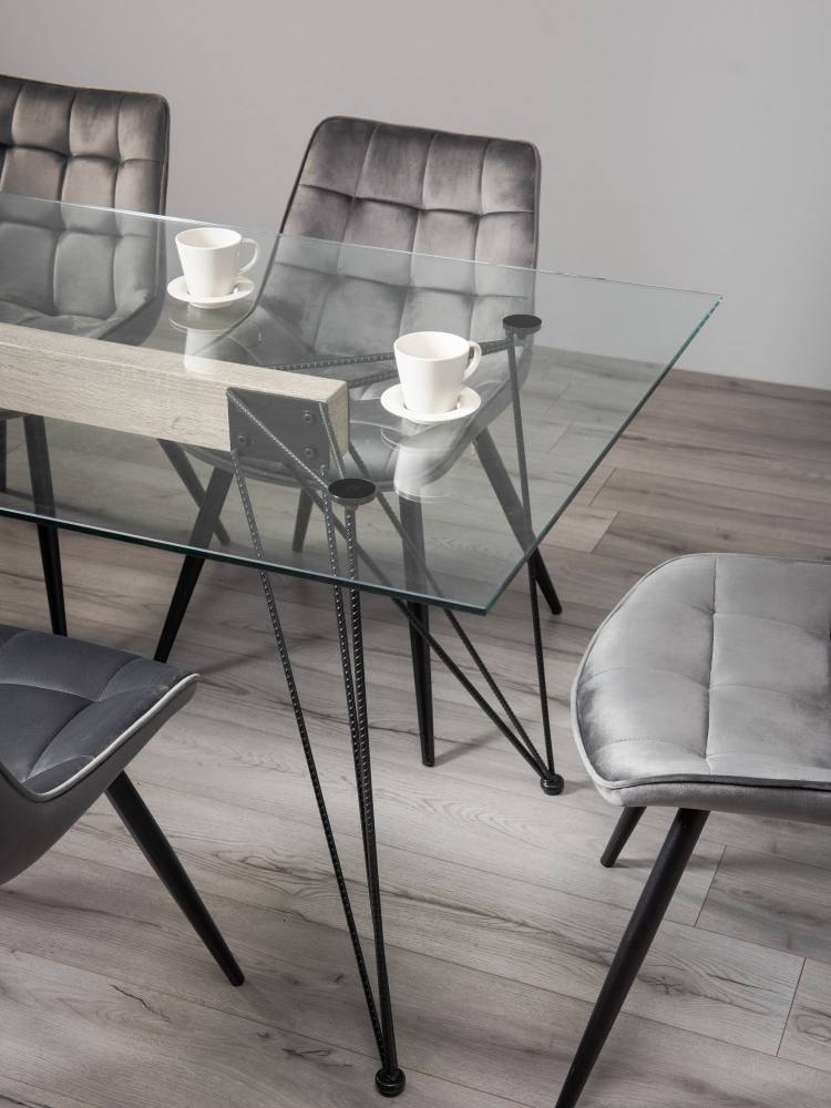 Close Up of the Bentley Designs Miro Clear Tempered Glass 6 Seater Dining Table & 6 Seurat Grey Velvet Fabric Chairs with Sand Black Powder Coated Legs