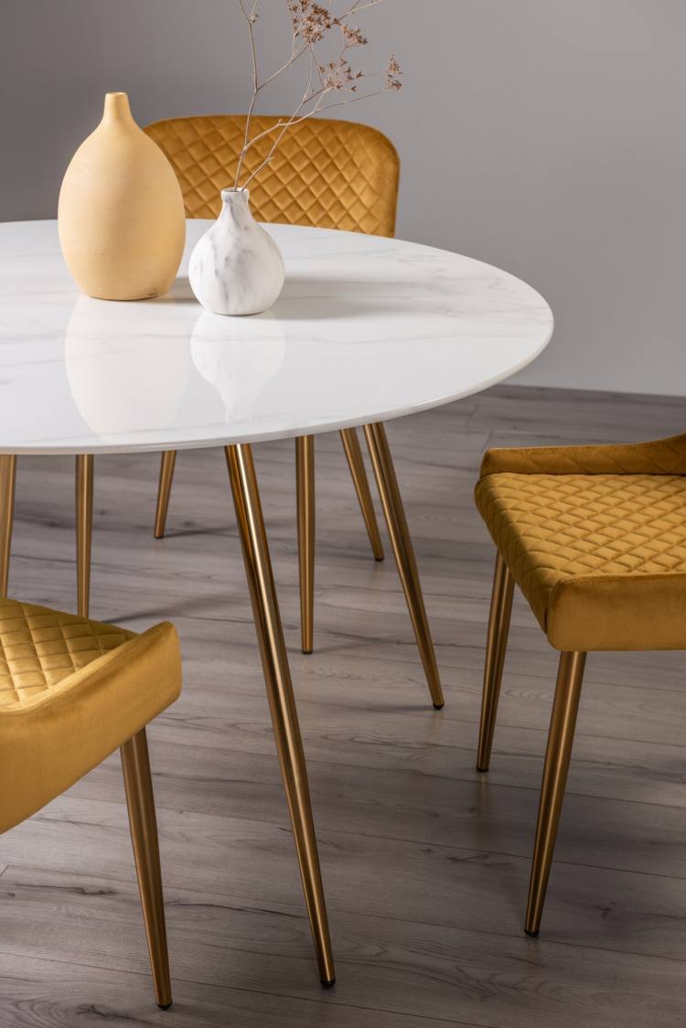 Close up of The Bentley Designs Francesca White Marble Effect Tempered Glass 4 Seater Dining Table and 4 Cezanne Mustard Velvet Fabric Chairs with Matt Gold Plated Legs