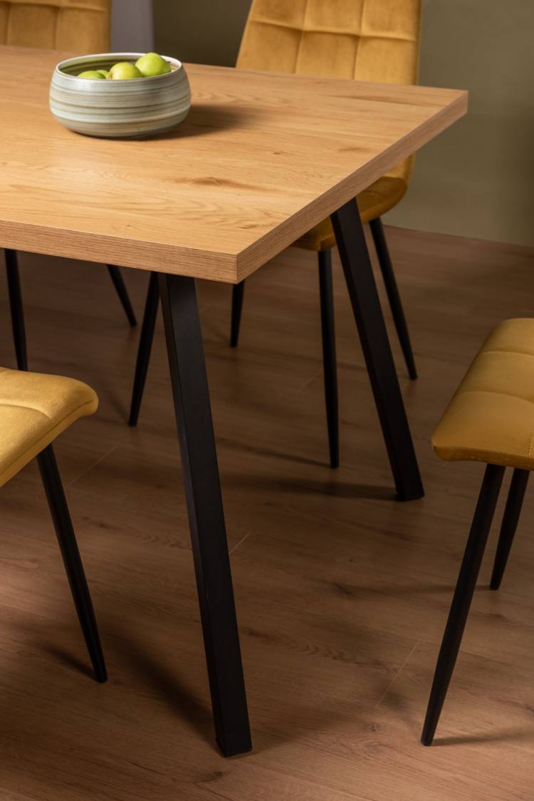 Close Up of The Bentley Designs Ramsay Rustic Oak Effect Melamine 6 Seater Dining Table with 4 Legs & 6 Mondrian Mustard Velvet Fabric Chairs with Sand Black Powder Coated Legs