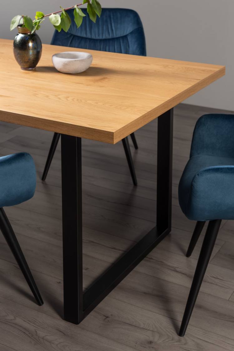 Close Up of the Bentley Designs Ramsay Rustic Oak Effect Melamine 6 Seater Dining Table with U Leg & 4 Dali Petrol Blue Velvet Fabric Chairs with Sand Black Powder Coated Legs