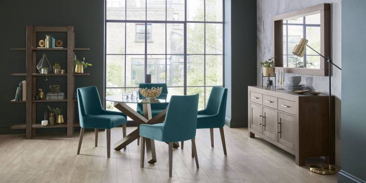 The Bentley Designs Turin Dark Oak Circular Glass Table on Display with Parts of the Turin Dark Oak Dining Range 