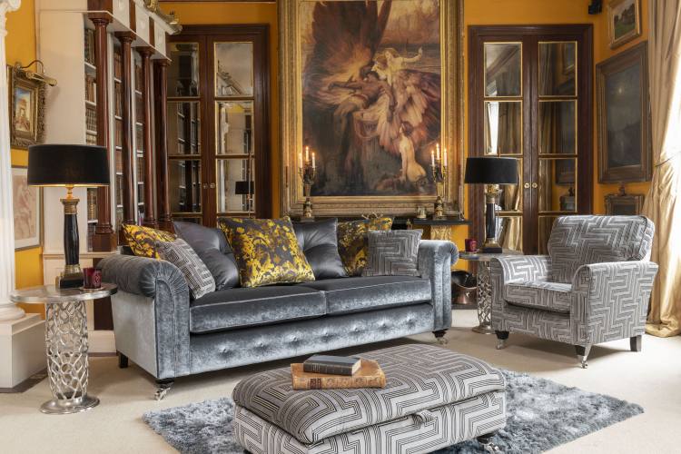 Grand sofa in fabric 1439, 3 pillows in 1303, 2 pillows (with button detail) in 1019, small scatter cushions in 1147, ebony/polished chrome castor legs. Accent chair in fabric 1147, ebony/polished chrome castor legs. Legged Ottoman in fabric 1147, ebony/p