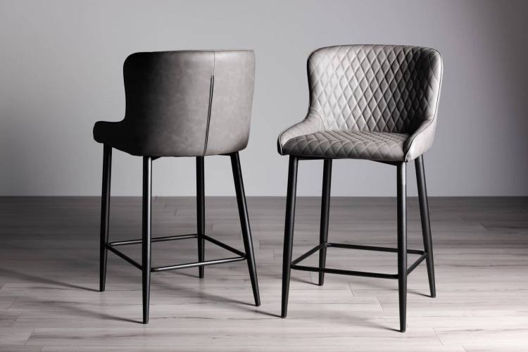 The Bentley Designs Cezanne Dark Grey Faux Leather Bar Stools with Sand Black Powder Coated Legs on Display
