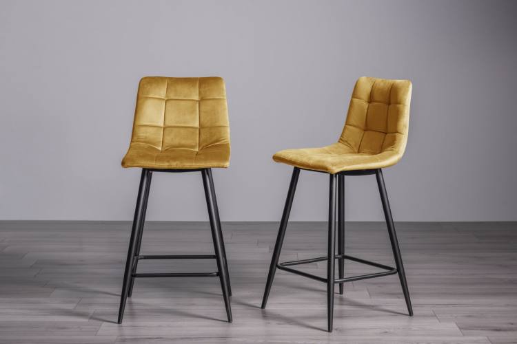 The Bentley Designs Mondrian Mustard Velvet Fabric Bar Stools with Sand Black Powder Coated Legs (Pair) on Display